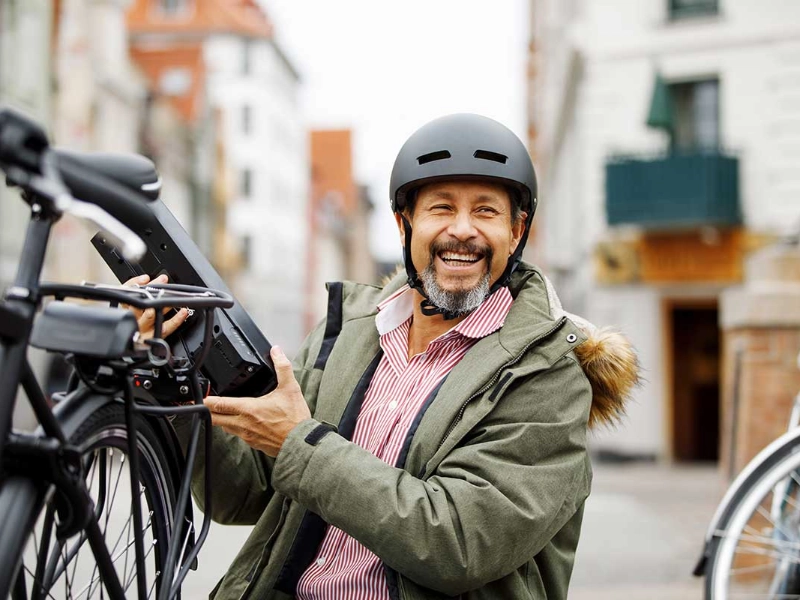 Ein lachender Mann neben seinem S-Pedelec